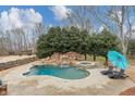 Lush backyard with a sparkling kidney-shaped pool and spa surrounded by mature trees, perfect for summer days at 102 Rosebury Dr, Canton, GA 30115