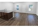 Unfurnished living room and kitchen area with hardwood style floors and natural lighting at 1112 Highwood Ln, Atlanta, GA 30344