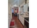 Open kitchen design with white cabinets, stainless steel appliances, and laminate wood flooring at 2335 Boulder Se Rd, Atlanta, GA 30316