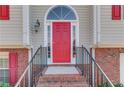 A vibrant red front door framed by brick steps and a decorative window above at 3110 Chandon Ln, Lawrenceville, GA 30044