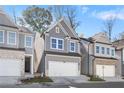 Attractive townhome showcasing a gray exterior, a pristine lawn, and an attached two-car garage at 686 Smokey Quartz Way, Kennesaw, GA 30144