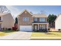 Two-story home with brick and gray siding and an attached two-car garage on a green lawn at 332 Hinton Farm Way, Dacula, GA 30019