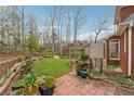 Well-maintained backyard with a brick patio, lush greenery, and a garden at 3620 Highpoint Rd, Cumming, GA 30041