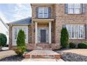 Close up of a brick home's front entrance with columns and manicured bushes at 5029 Tarry Glen Dr, Suwanee, GA 30024