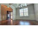 Inviting entryway with hardwood floors, a transom window, wainscoting, coffered ceilings, and a wreath on the front door at 207 Birchwood Dr, Loganville, GA 30052