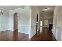 Open-concept entryway with hardwood floors, archways, and wainscoting, leading to multiple rooms in the home at 207 Birchwood Dr, Loganville, GA 30052