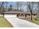 Traditional brick house with a long driveway, a white garage door, and a quaint front porch at 2722 Oswood Dr, Tucker, GA 30084