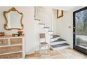 Inviting entryway with staircase, dresser, and elegant gold-framed mirror, creating a warm welcome at 2528 Fernleaf Nw Ct, Atlanta, GA 30318