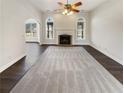 Bright living room with fireplace, arch windows, and dark floors at 149 Fishers Mill Dr, Mcdonough, GA 30252