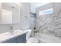 Updated bathroom featuring marble tile, modern vanity, and bathtub with shower at 174 Howard Nw St, Atlanta, GA 30314