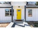 Close-up of the front entrance showing the bright yellow door, white siding, and covered porch at 174 Howard Nw St, Atlanta, GA 30314