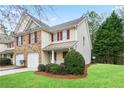 Charming townhome with brick and siding, red shutters, green lawn, and covered front porch at 184 Darbys Crossing Ct, Hiram, GA 30141