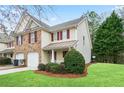 Two-story home boasts a well-kept lawn and an attached one-car garage at 184 Darbys Crossing Ct, Hiram, GA 30141