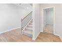 Bright hallway featuring hardwood floors, a staircase with iron railings, and a doorway leading to another room at 7164 Brushwood Bend (Lot 111), Lithonia, GA 30058