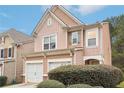 Charming two-story home with double garage and manicured lawn and shrubs at 7717 Bellmist Dr, Fairburn, GA 30213