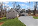 Rear exterior of the home with an attached three-car garage and lush green lawn at 331 Terrell Sw Dr, Marietta, GA 30064