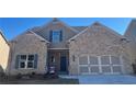 Charming brick home featuring a two-car garage, inviting front entry, and well maintained landscaping at 3828 Southfield Ct, Loganville, GA 30052