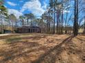 Single-story brick home with a covered porch surrounded by a lawn and woods at 770 Prickett Rd, Douglasville, GA 30134