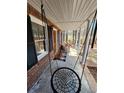 Relaxing covered front porch with a unique circular swing and view of the yard at 770 Prickett Rd, Douglasville, GA 30134