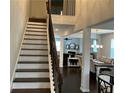 Bright foyer featuring hardwood stairs, dark railing, and natural light, leading into the dining and living spaces at 140 Craines Vw, Covington, GA 30014