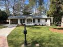 Inviting home with lush lawn, mature trees, and a classic white exterior at 2466 Sharondale Ne Dr, Atlanta, GA 30305