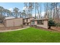 View of home exterior showing the front yard, tidy lawn, and mature trees at 9480 Hillside Dr, Roswell, GA 30076