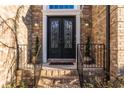 Elegant front door with decorative glass and black metal detailing; brick steps, and manicured potted plants at 271 Double Gate Ct, Sugar Hill, GA 30518