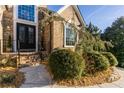 Elegant home entrance with decorative glass double doors, brick steps, and lush landscaping at 271 Double Gate Ct, Sugar Hill, GA 30518