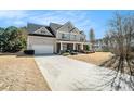 Beautiful two-story home with a covered front porch, lush landscaping, and attached garage at 1200 St James Pl, Loganville, GA 30052