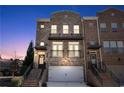 Charming brick townhome with inviting entrance and attached two-car garage at dusk at 3185 Quinn Pl, Atlanta, GA 30341