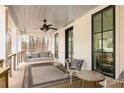 Inviting covered porch with a swing, ceiling fan, and comfortable seating area perfect for relaxation at 9229 Selborne Ln, Chattahoochee Hills, GA 30268