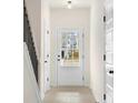 Hallway view with a white door leading to the outside and several doors for bedroom and bathroom access at 735 Shetland Trl, Cartersville, GA 30121