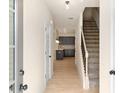 Bright entryway featuring wood floors leading to a modern kitchen and staircase, welcoming guests with style and functionality at 735 Shetland Trl, Cartersville, GA 30121