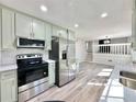 Charming kitchen features stainless steel appliances, light green cabinets and bright white countertop at 101 Summer Pond Trl, Lawrenceville, GA 30046