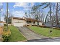 Ranch home with a long driveway and beautiful green lawn at 5176 Downs Way, Norcross, GA 30093