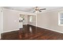 Open living room showcasing hardwood floors and neutral paint, flowing seamlessly into the kitchen and dining area at 1743 Thomas Ter, Decatur, GA 30032