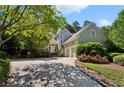 Beautiful home exterior featuring a well-manicured lawn, mature trees, and an attached two-car garage at 857 Stovall Ne Pl, Atlanta, GA 30342