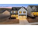 Elegant two-story home with a striking black and white exterior, a well-manicured lawn, and a welcoming entrance at 1590 Branthaven Ln, Auburn, GA 30011