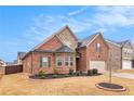 Attractive brick home with a well-maintained lawn, enhanced by a two-car garage and complementary stone details at 182 Broder Farms Dr, Stockbridge, GA 30281