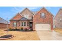 Charming brick home with a manicured lawn, complemented by a two car garage and stone architectural features at 182 Broder Farms Dr, Stockbridge, GA 30281