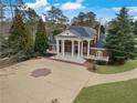 View of the brick home with white columns and a spacious driveway at , Roswell, GA 30075