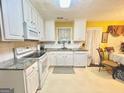 Bright kitchen featuring white cabinetry, granite countertops, and modern appliances at 2782 Wynhaven Oaks Way, Lawrenceville, GA 30043