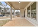 Covered porch with concrete flooring, column supports, recessed lighting, and a view of the landscaped front yard at 5115 N Pratt St, Covington, GA 30014