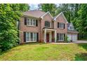 Charming brick home with black shutters, a well-kept lawn, and an attached two-car garage at 5485 Brookstone Nw Dr, Acworth, GA 30101