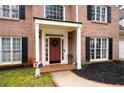 Inviting front porch with a red door, brick walkway, and black mulch at 5485 Brookstone Nw Dr, Acworth, GA 30101