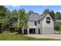 Rear exterior with outdoor deck, spacious garage, and round window detailing at 11260 Houze Rd, Roswell, GA 30076
