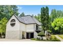 Rear exterior features a large garage and unique architectural details, with a stone base and decorative round window at 11260 Houze Rd, Roswell, GA 30076