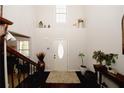 Bright, two-story foyer with hardwood floors, a decorative front door and decor, and a staircase on the left at 139 6Th St, Auburn, GA 30011