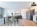 Dining area with a table and chairs, stainless steel refrigerator, and light wood floors at 8904 Creekwood Ct, Riverdale, GA 30274