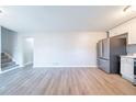 A spacious open-plan kitchen space with light wood floors, stainless steel refrigerator, and light-colored walls at 8904 Creekwood Ct, Riverdale, GA 30274